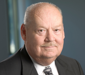 John A. Hackett, CIC, professional headshot in a suit and tie.