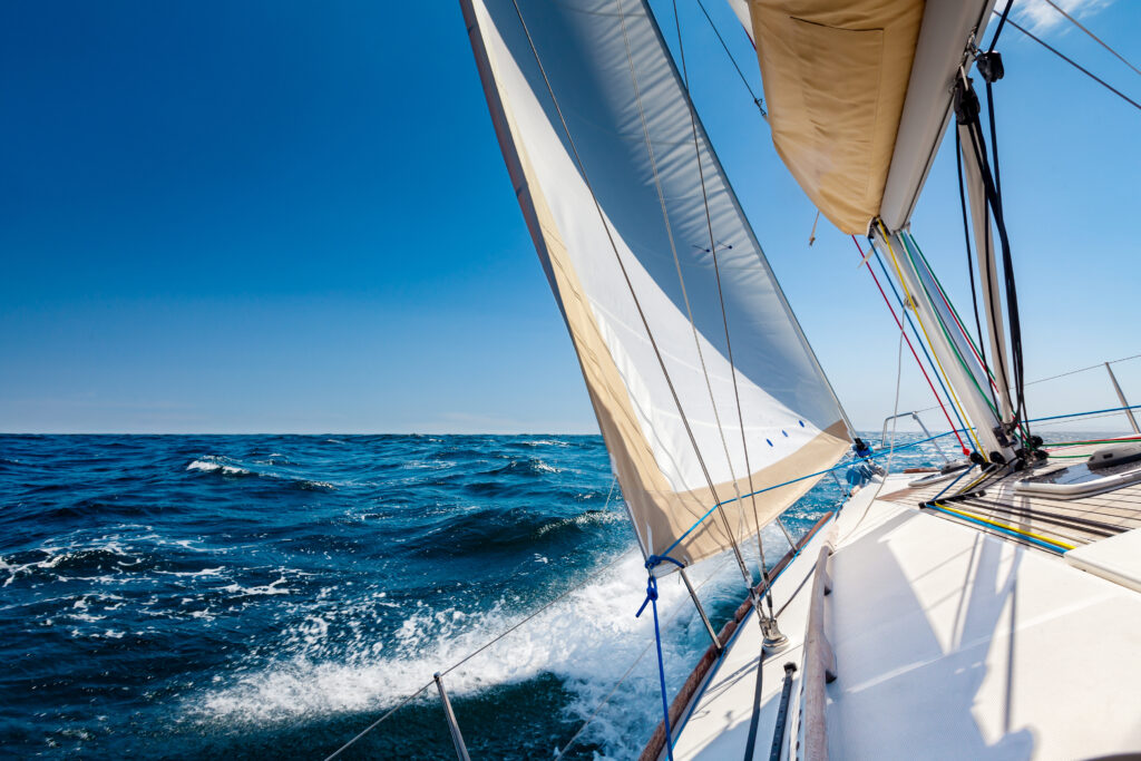 Sailboat on blue ocean under clear sky, showcasing specialty coverage options.