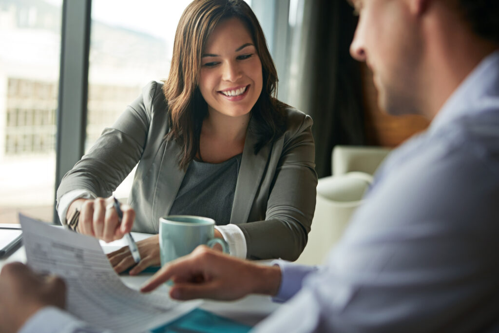 Woman reviewing documents with a colleague, possibly discussing umbrella coverage options.
